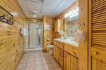 Lower level bathroom with a double vanity and a large shower stall 